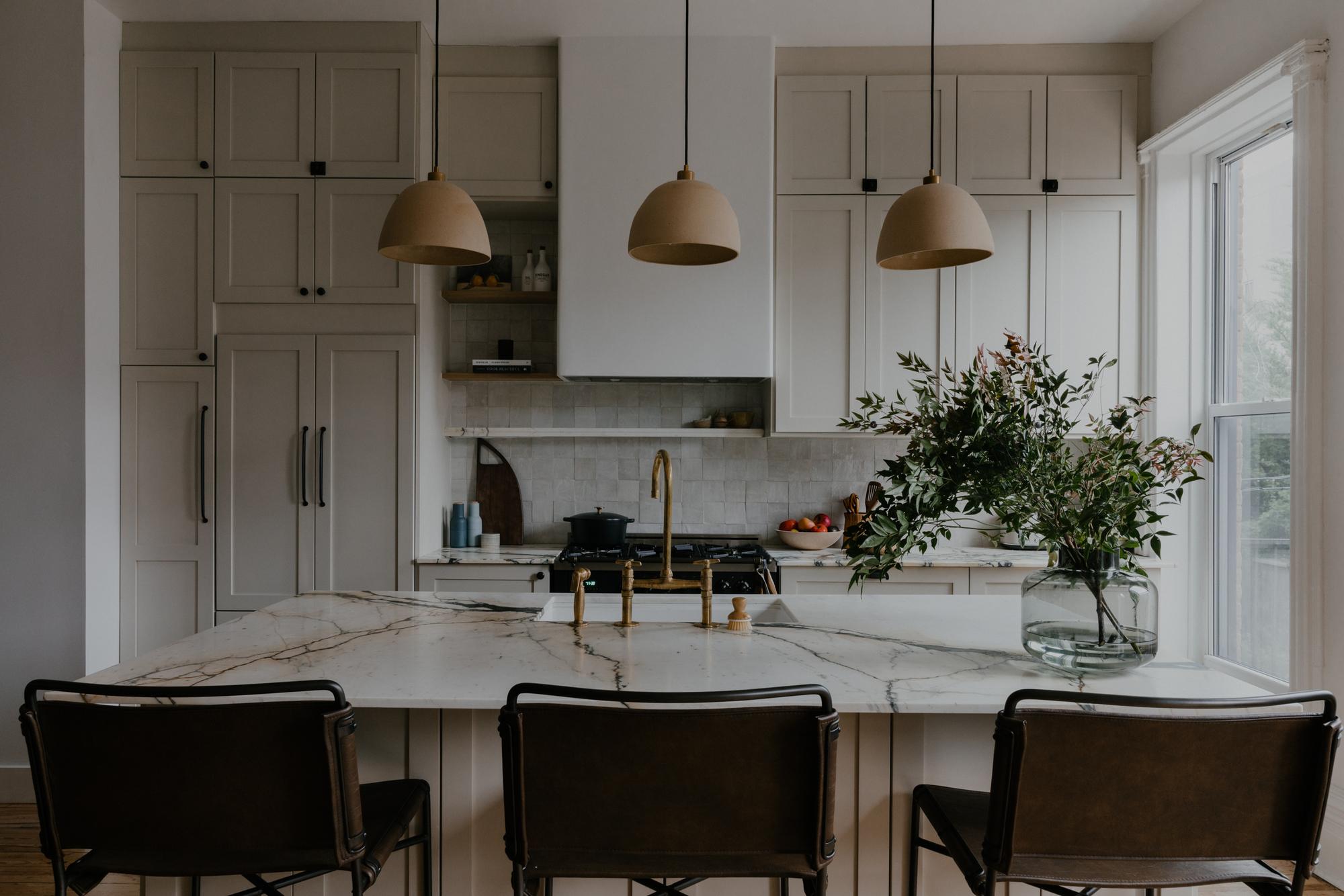 Warm, modern kitchen with cream cabinetry, island, and natural light